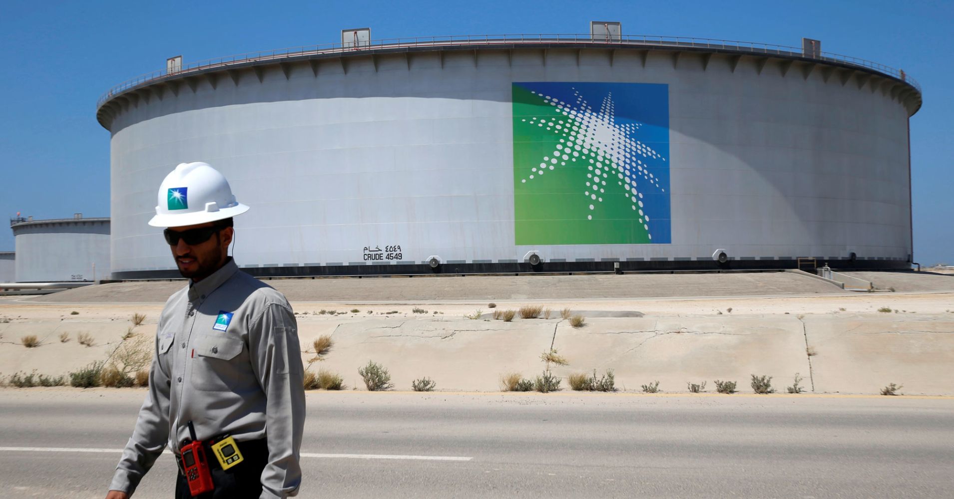 An Aramco employee walks near an oil tank at Saudi Aramco's Ras Tanura oil refinery and oil terminal in Saudi Arabia.