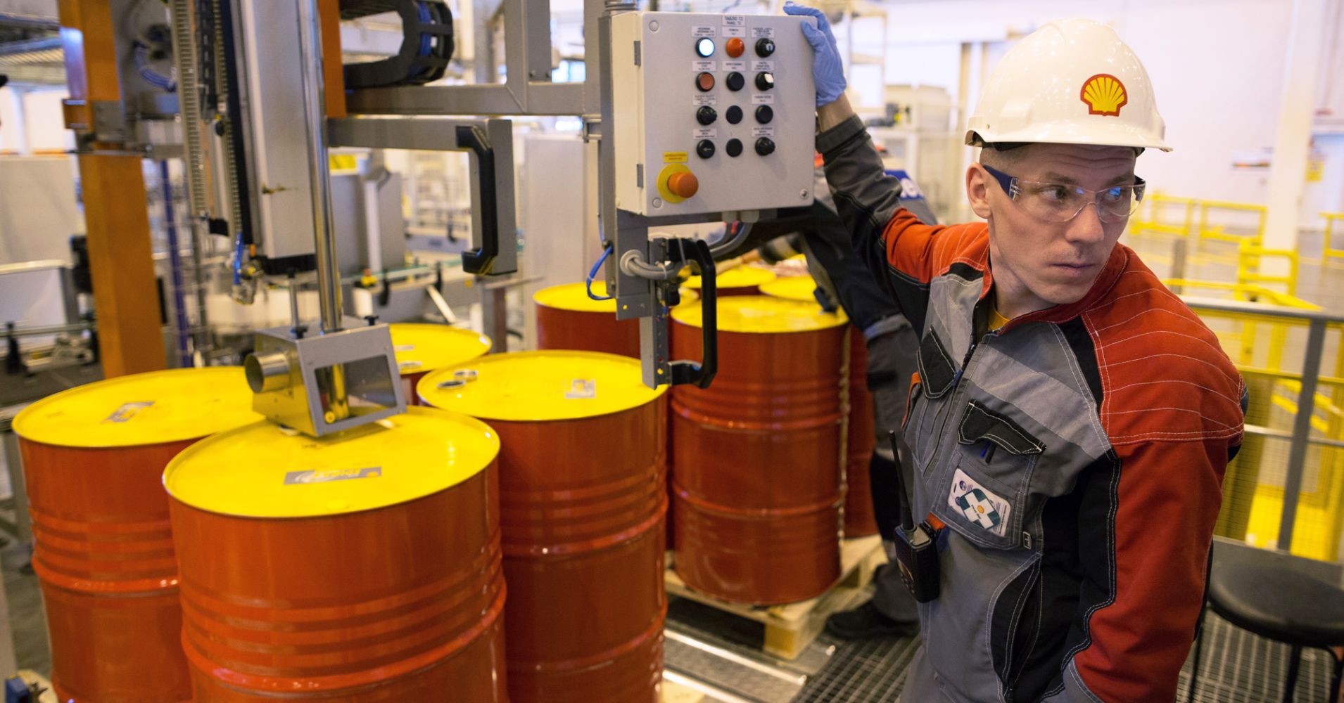 An employee holds a control panel as barrels are filled with lubricant oil for shipping at Royal Dutch Shell Plc's plant in Torzhok, Russia, March 21, 2014.