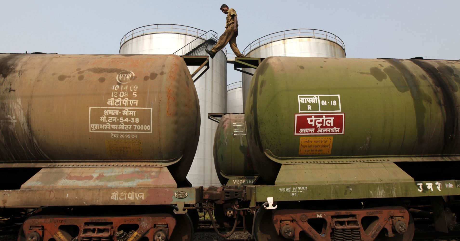 A worker walks atop a tanker wagon to check the freight level at an oil terminal on the outskirts of Kolkata.