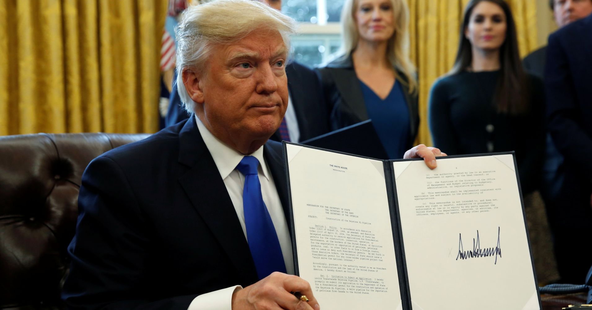 President Donald Trump holds up a signed executive order to advance construction of the Keystone XL pipeline at the White House in Washington January 24, 2017.