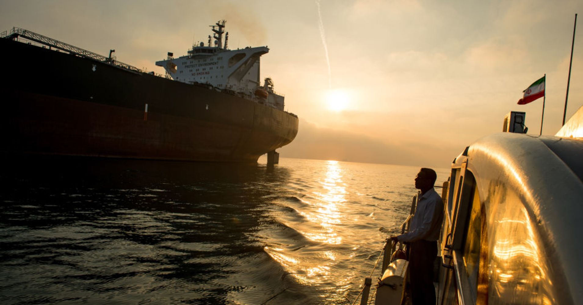 A support vessel flying an Iranian national flag sails alongside the oil tanker 'Devon' as it prepares to transport crude oil to export markets in Bandar Abbas, Iran, on Friday, March 23, 2018.