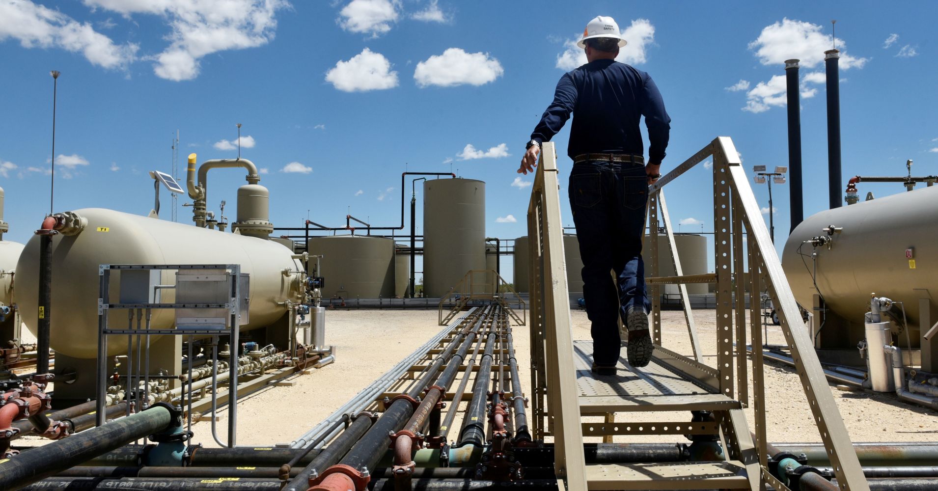 A worker walks through an oil production facility owned by Parsley Energy in the Permian Basin near Midland, Texas, August 23, 2018. 