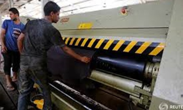 Workers remove leather from a machine in the factory at El Robbiki Leather City in Badr City, east of Cairo, Egypt, August 14, 2017. REUTERS/Amr Abdallah Dalsh