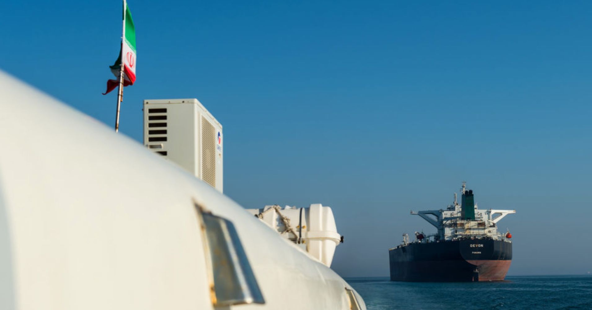 A support vessel maneuvers near the crude oil tanker 'Devon' as it sails through the Persian Gulf towards Kharq Island oil terminal to transport crude oil to export markets in Bandar Abbas, Iran, on Mar. 23, 2018.